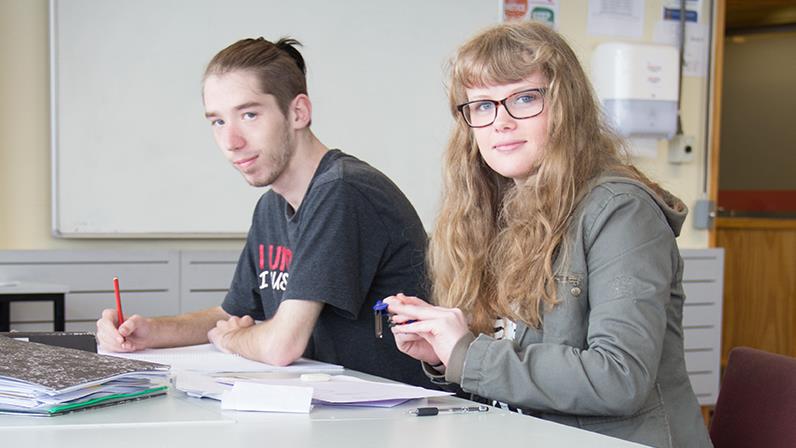 Two UCOL learners sitting in a classroom