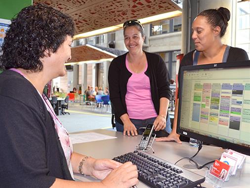 Palmerston North UCOL students receiving assistance from a staff member.