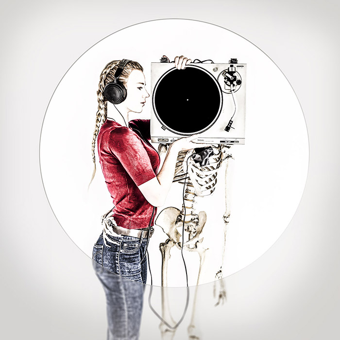 Portrait of a women holding a turntable in front of the skull of a standing human skeleton
