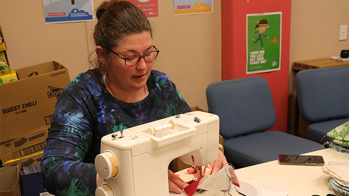  Library Assistant Lynda Whale making a mask with a sewing machine