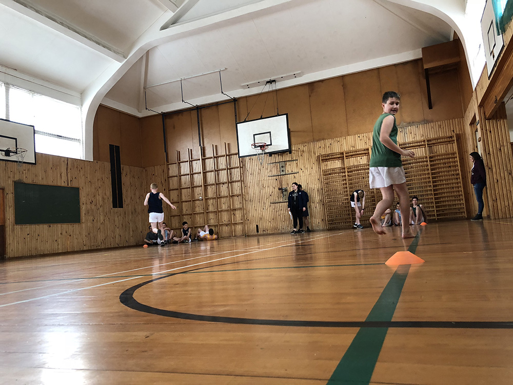 Students running in an indoor court