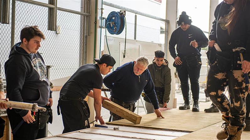 UCOL | Te Pūkenga construction students and lecturer working at the workshop