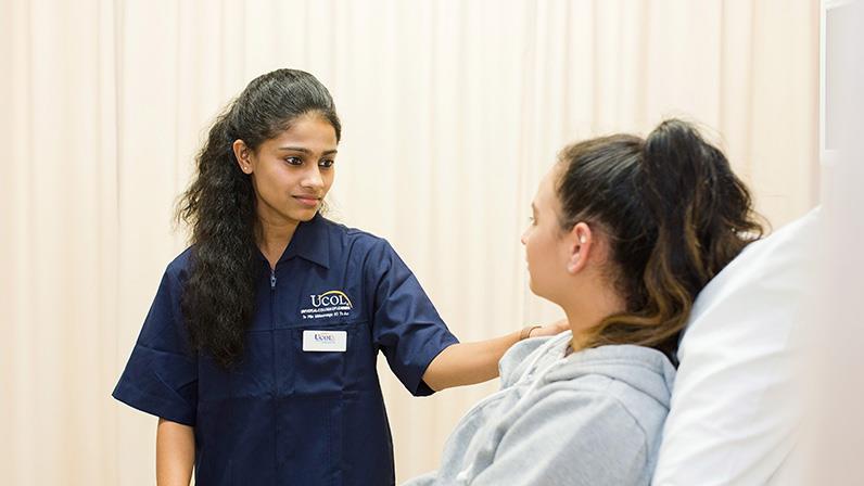 A UCOL student attends to a patient.