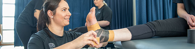 Student taping a person's ankle