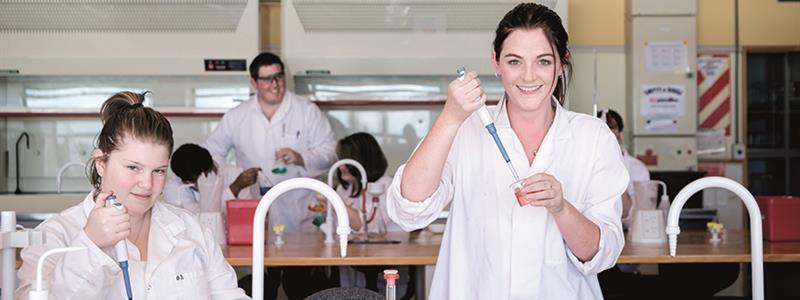 A photograph of students in a science laboratory at UCOL injecting liquid into beakers