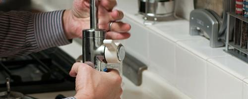A person adjusting a tap fitting