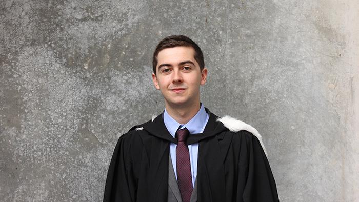 Portrait of Chris Percy in a graduation gown