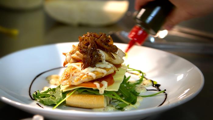 A restaurant meal being plated A restaurant meal being plated