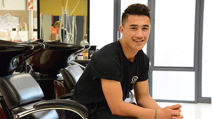 A young man sitting at the hair washing station at a hair salon