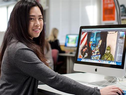 A photograph of a young lady at a computer screen featuring graphic design art work.