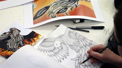 A close-up photograph of a student sketching a bird