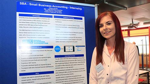 Brittany Burnett show off their posters at the Industry Project Internship Showcase
