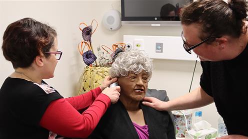 Careerforce Apprenticeship Advisor, Anne Meyer, instructs how to take the patient’s temperature, complete a glucose test, and use a stethoscope on a specialist mannequin in the hospital room of Te Whaioranga.
