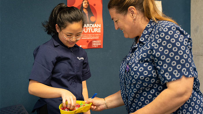 A nurse giving candy to a UCOL student