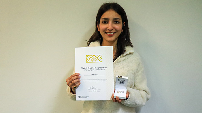 Sahiba Kaur holding her COVID-19 Response Recognition award