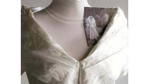 A photograph of a refashioned bridal dress with the original photograph of the bride