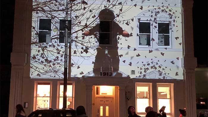 A person on a bike projected on to a building