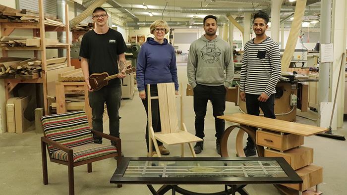 A photograph of UCOL furniture design and making students in the workshop with their furniture