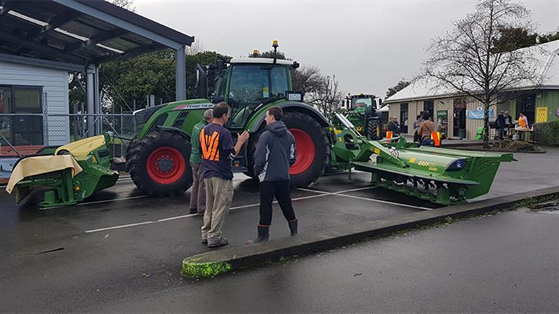 A photograph of Taratahi Agriculture training center huge green tractor and two men standing close to it and talking