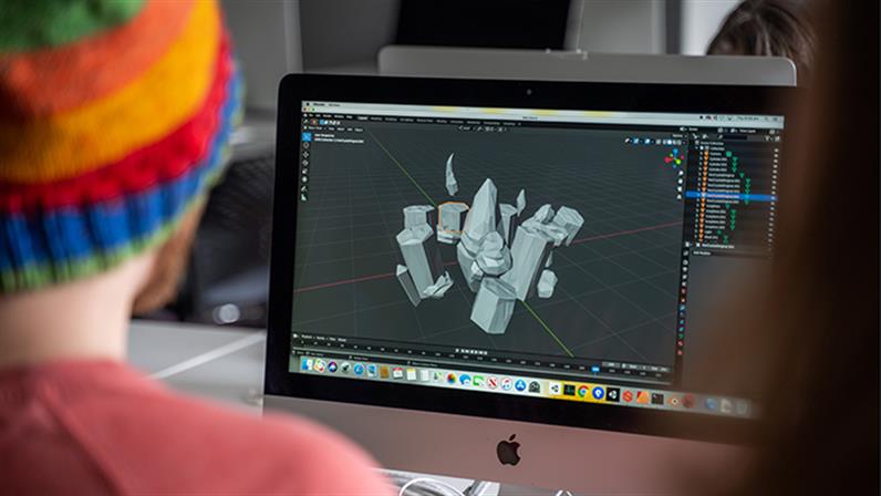 A photograph of a student works on a Mac at the Whanganui School of Design