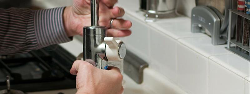 A person adjusting a tap fitting