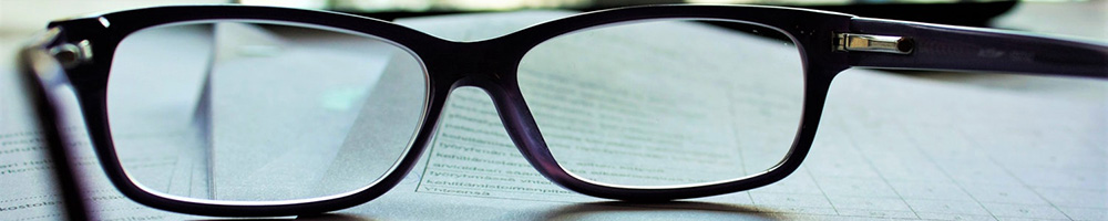 A photograph of a contract viewed through a pair of reading glasses