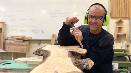 A photograph of UCOL Furniture Design Staff member Andy Halewood in a workshop working on a piece of furniture for charity.