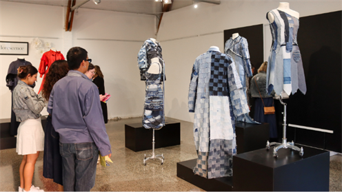 Roman Sarki (left) looks at his collection of garments