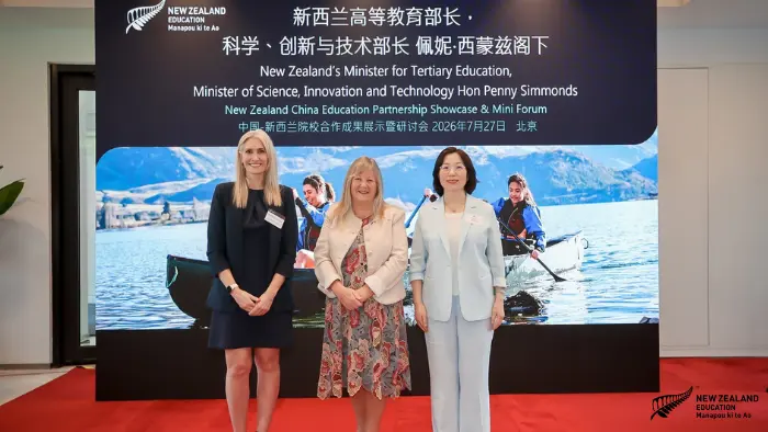 a group of women standing in front of a large screen