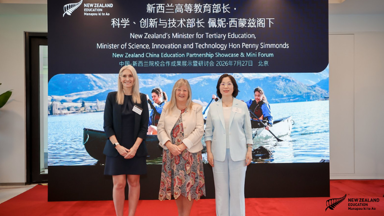 a group of women standing in front of a large screen