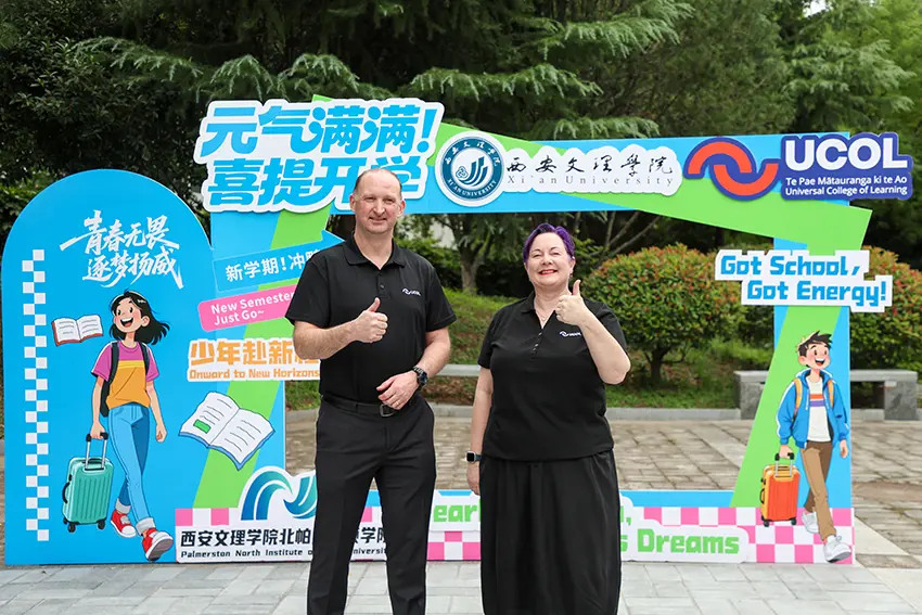 a man and woman standing in front of a sign