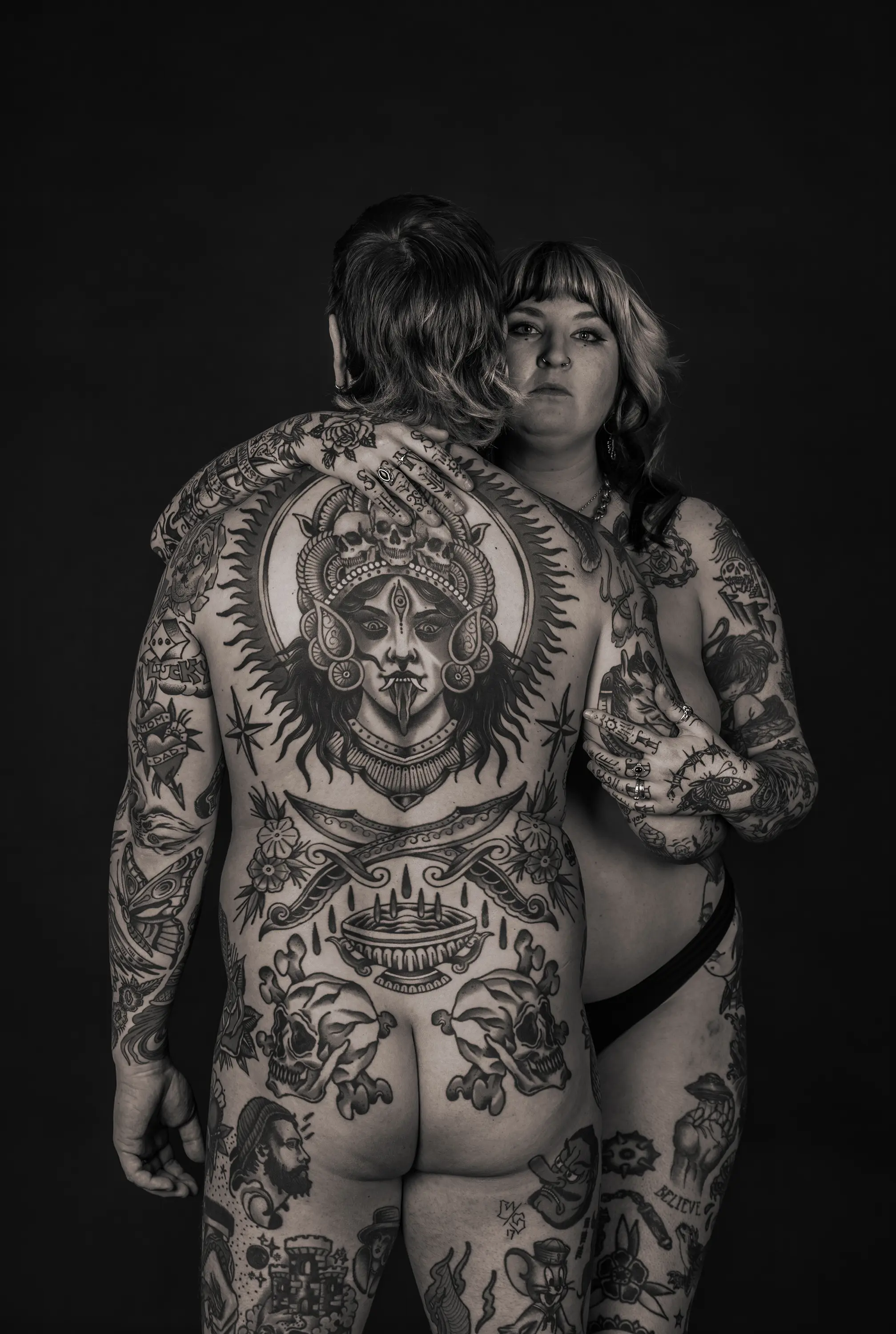 a man and woman with tattoos on their back