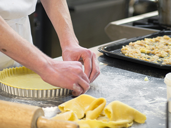 A student chef preparing a tart.