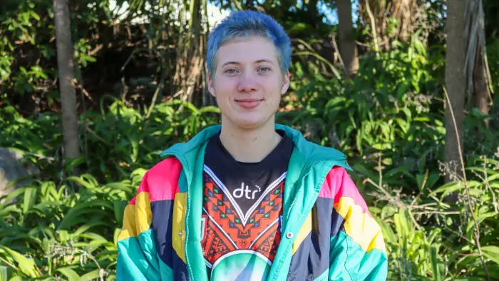 a person with blue hair in a colorful jacket