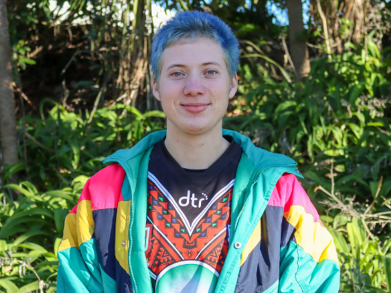 a person with blue hair in a colorful jacket