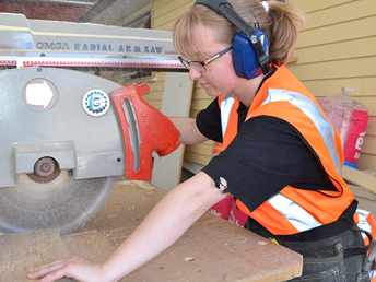 A young person working on a skill saw in a workshop at UCOL 