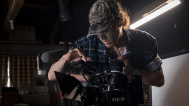 a man in a hat working on a camera