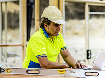 A construction worker using a laptop