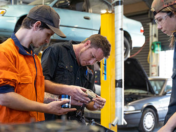 A UCOL lecturer and learners looking parts of a car at a workshop at UCOL.