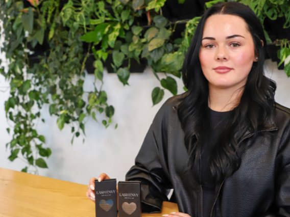 a woman sitting at a table holding two small boxes