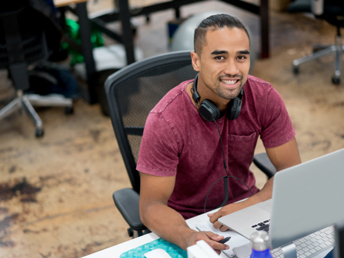 a man sitting at a desk with headphones on
