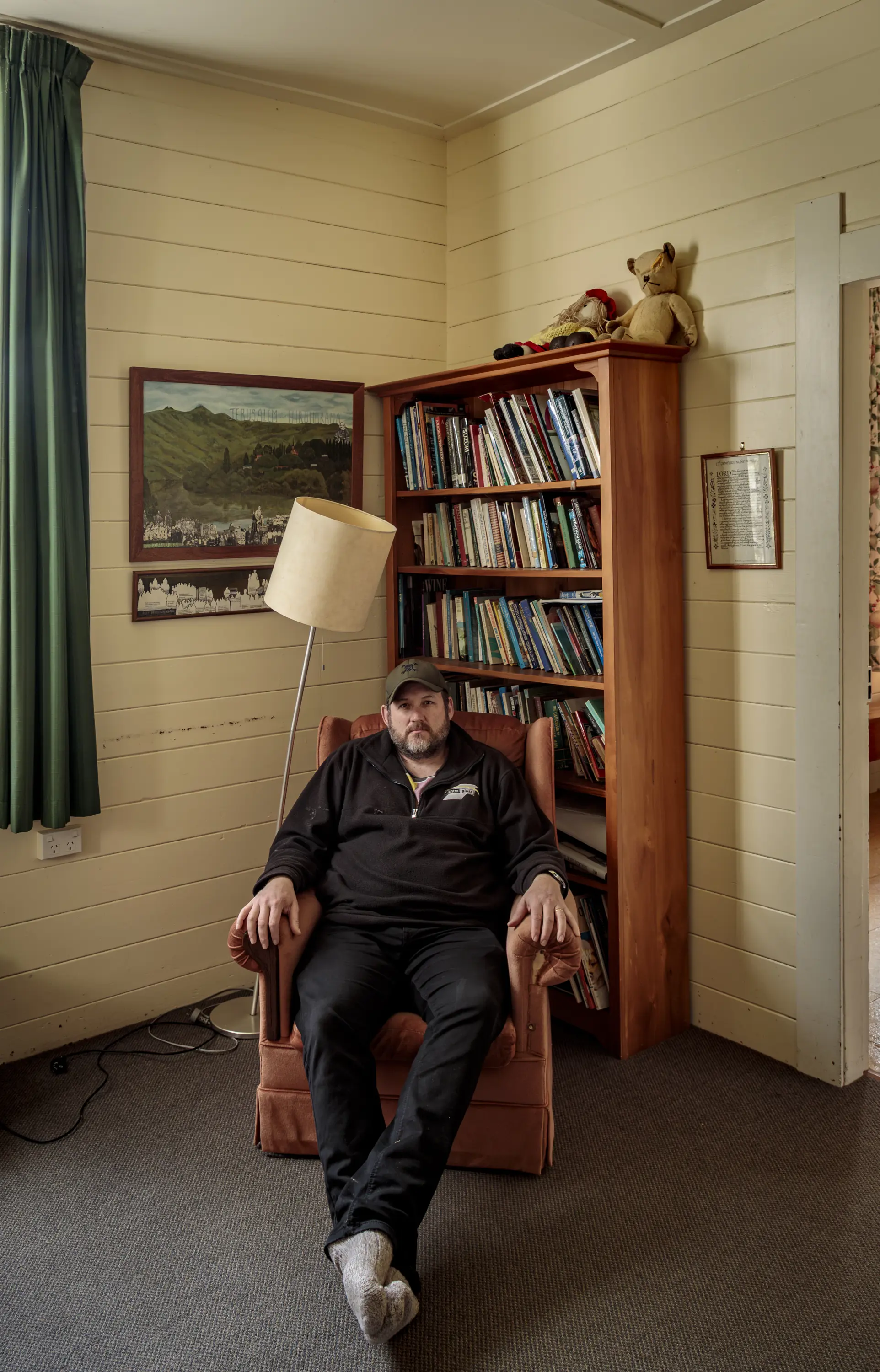 a man sitting in a chair in front of a bookcase