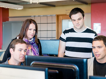 A group of people looking at a computer screen