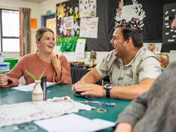 An early childhood class where students are interacting happily with each other and the male student has his hair with lot of knots.