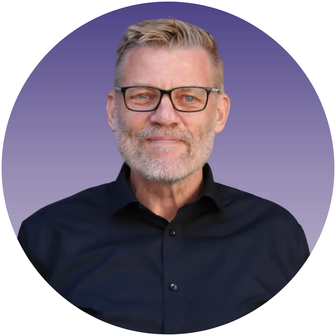 a man with glasses smiling at the camera