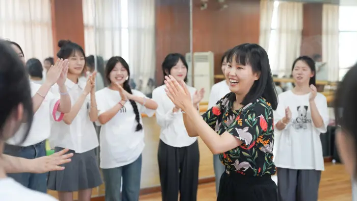 a group of women clapping and smiling