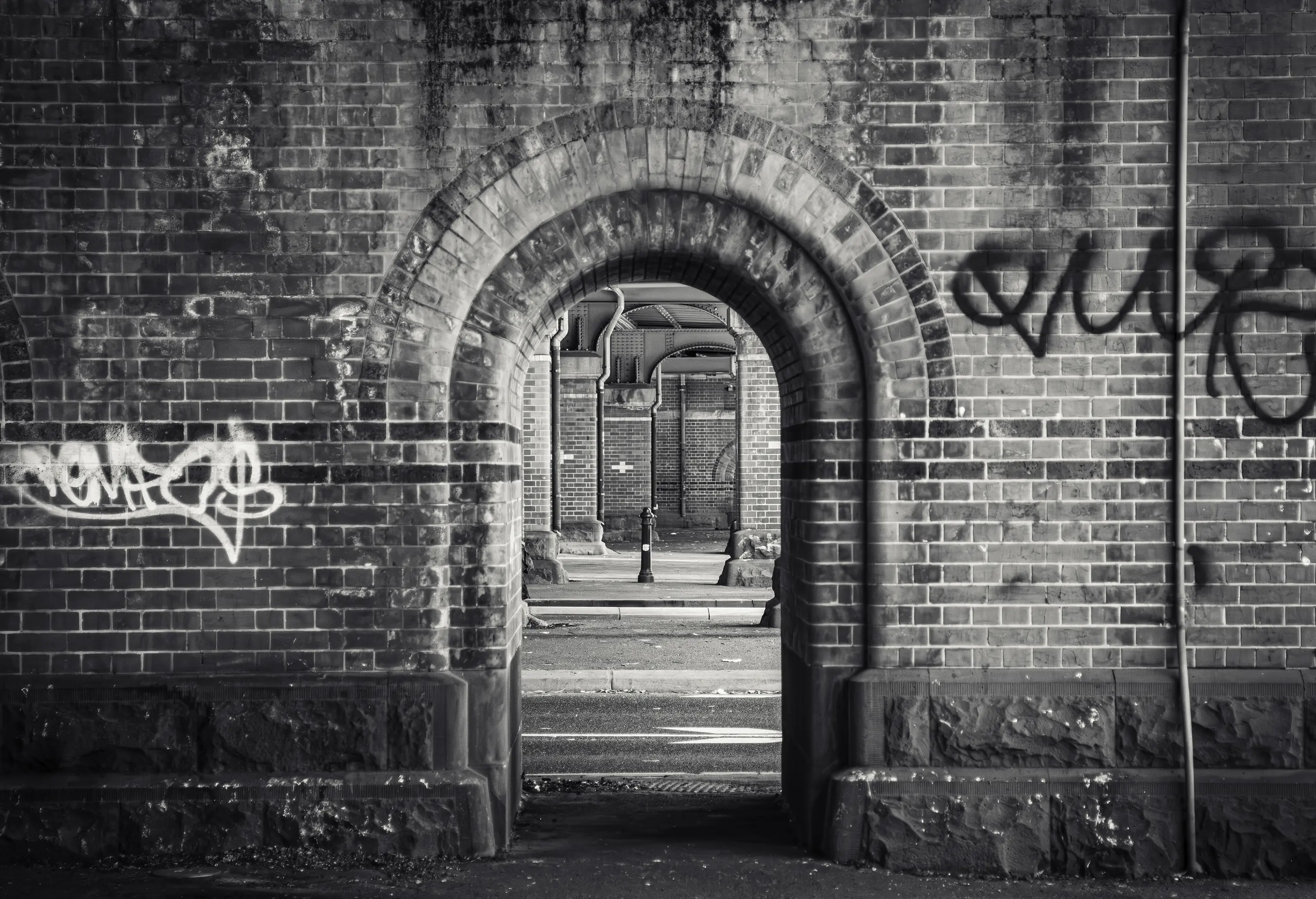 a brick archway with graffiti on it