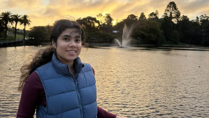 a woman standing in front of a water fountain