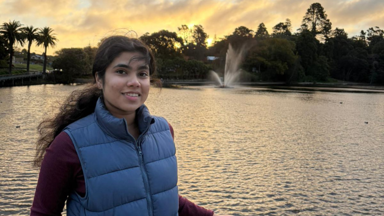a woman standing in front of a water fountain