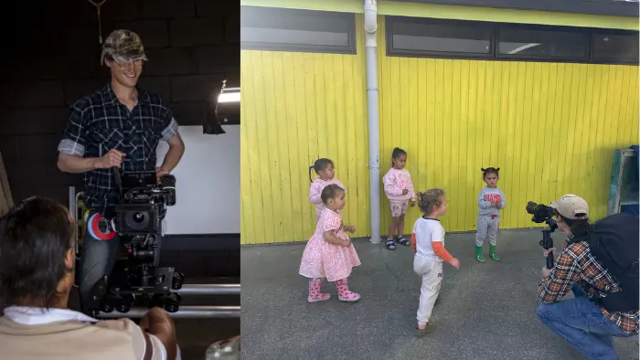a man holding a camera next to a group of children